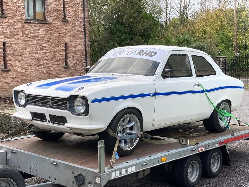 Red Ford Escort XR3 secured on an open transporter