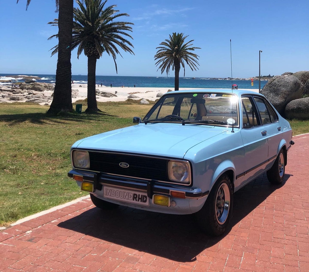 Light blue Ford Escort by the beach