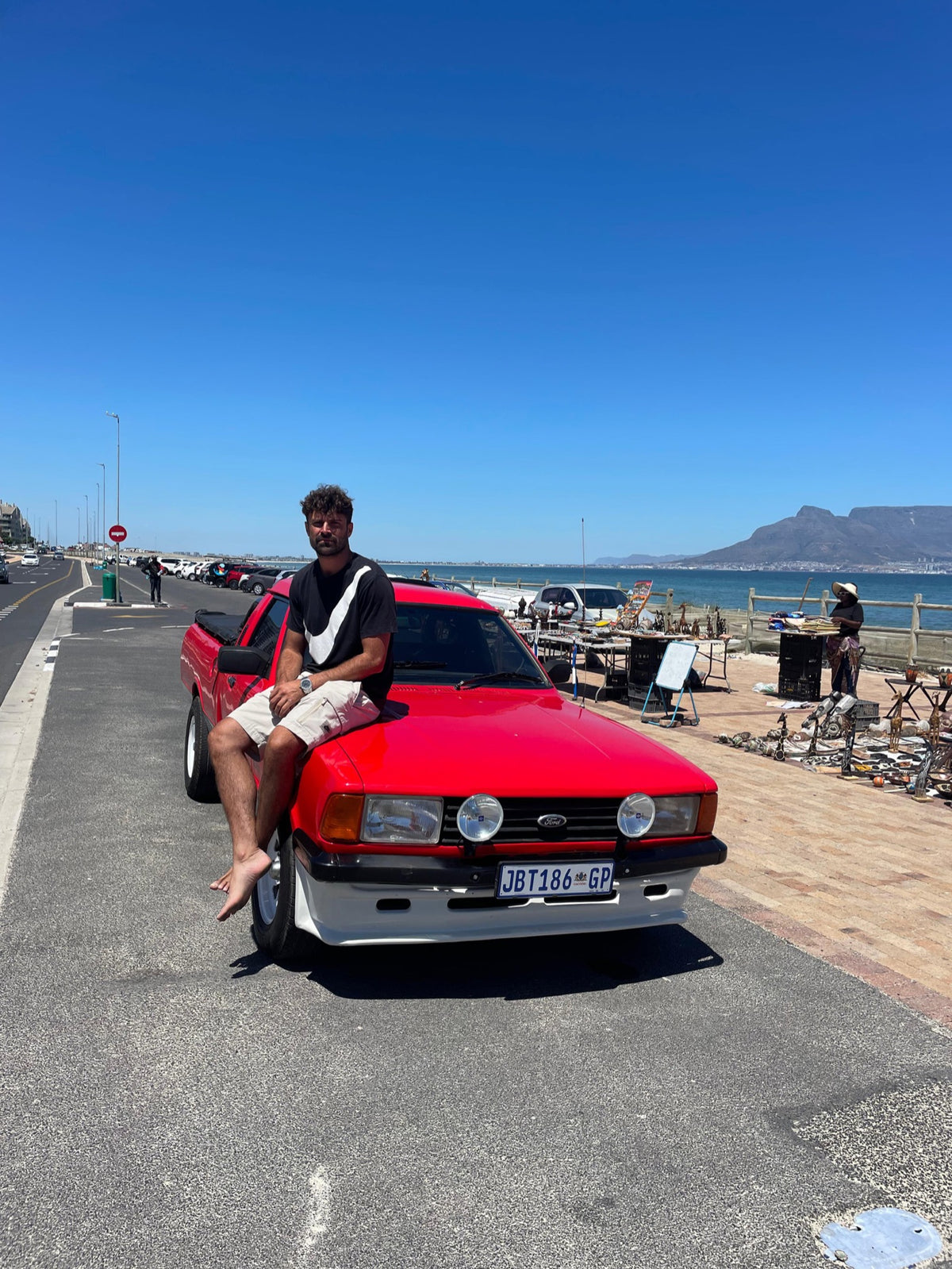 Owner seated on a red Ford Bantam with Table Mountain behind