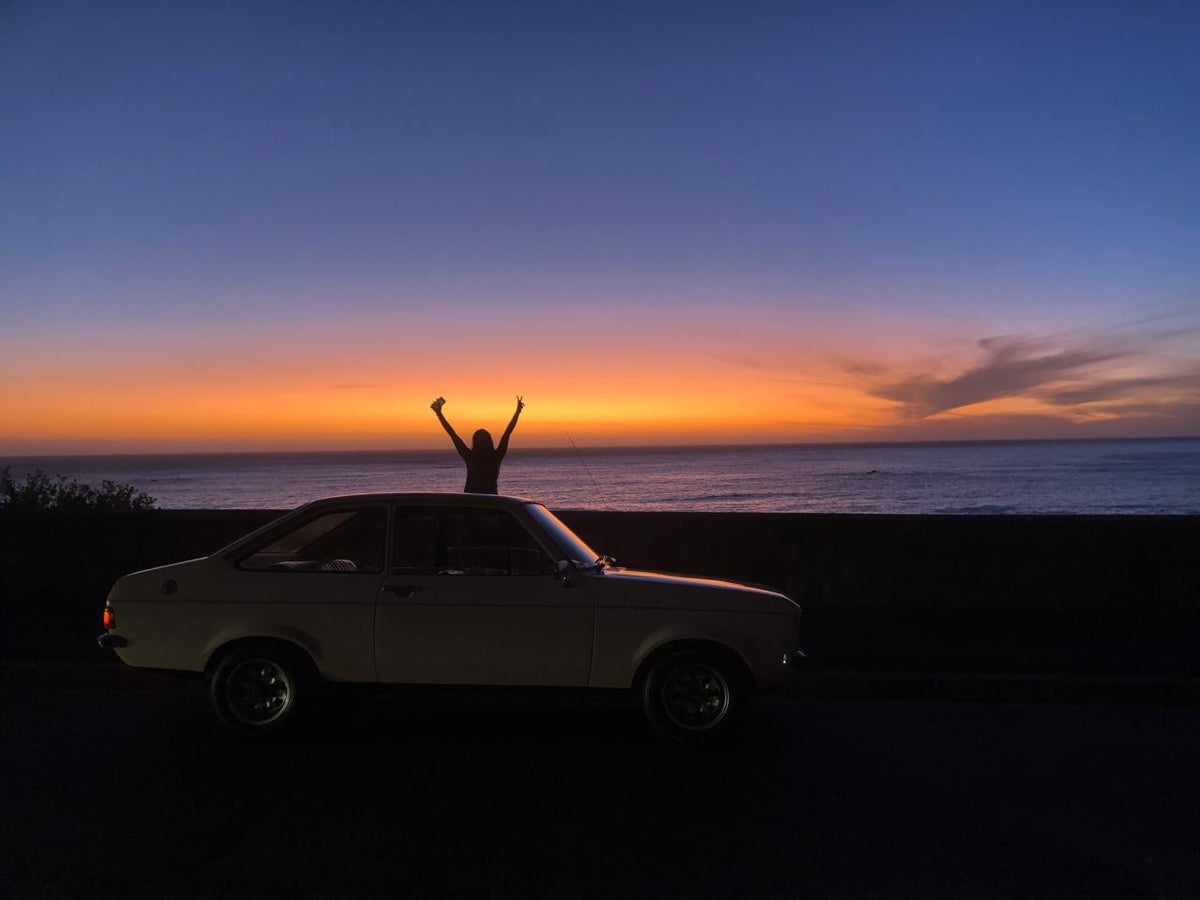 Classic Ford Escort silhouette at sunset by the sea
