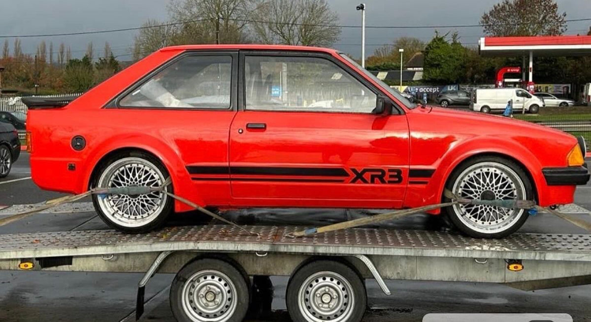 Red Ford Escort XR3 secured on a transporter