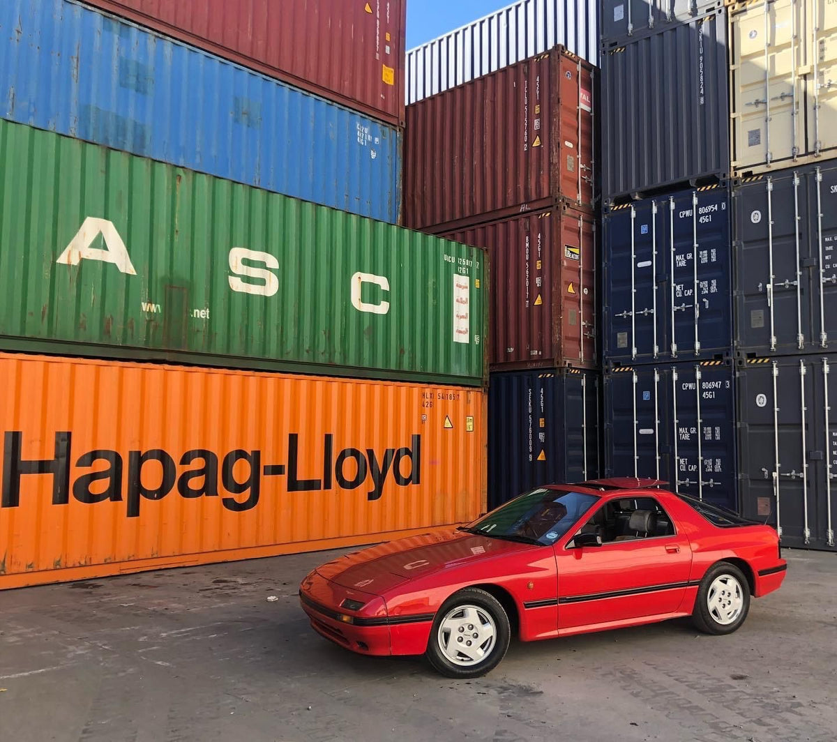 Red Mazda RX-7 at a container yard