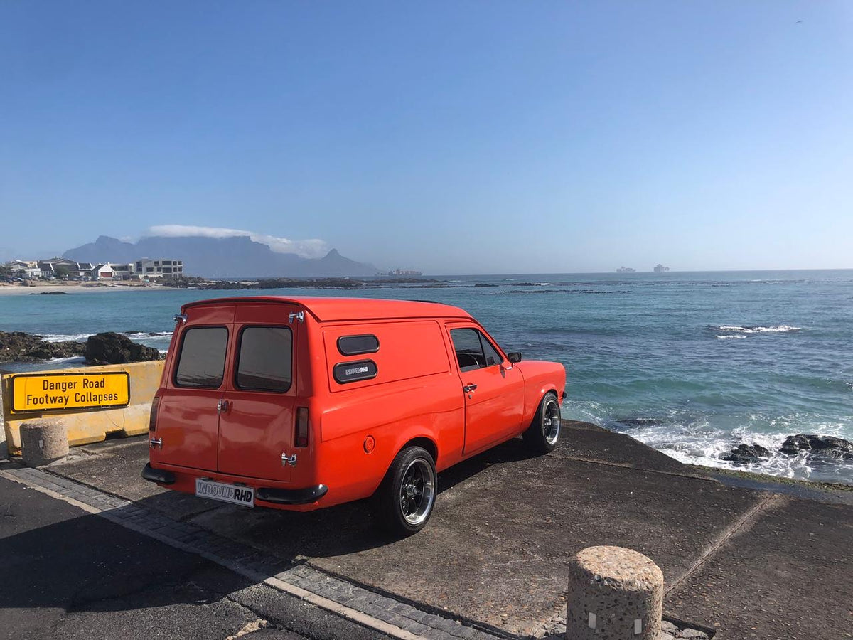 Orange panel van parked beside the Cape Town coast