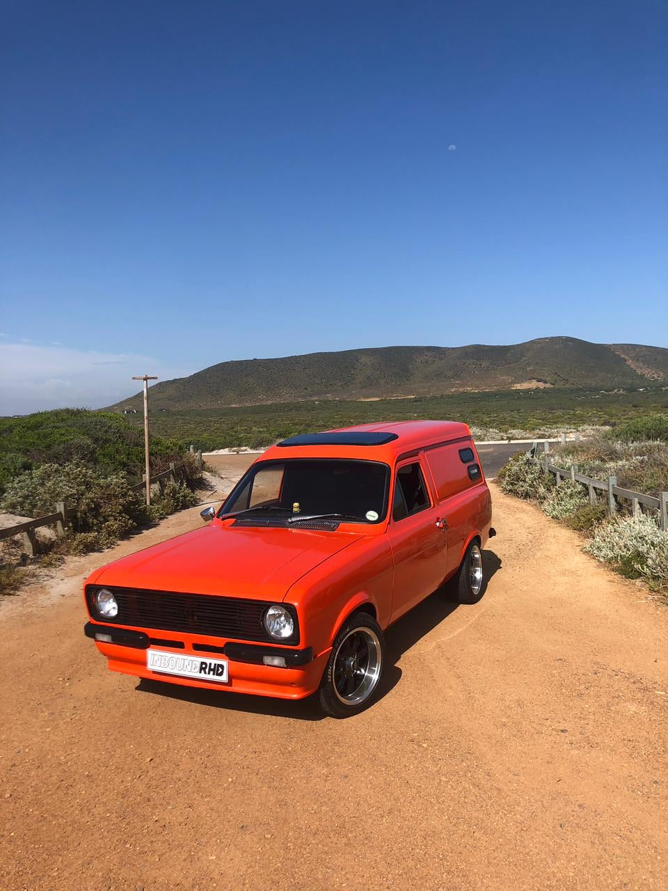 Orange panel van on a fynbos dirt road